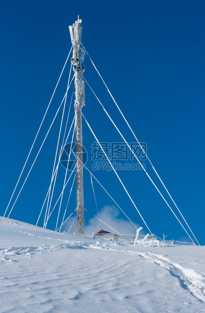 美丽的冬季红糖霜通讯塔和山顶的雪地漂浮在蓝天空背景的山顶上综合图像具有相当深的田野锐利度图片