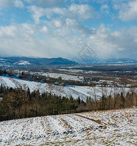 冬季山地景观坡野林和远处博戈罗德沙尼区伊万诺弗兰基夫斯克地区乌兰的村庄有田地图片