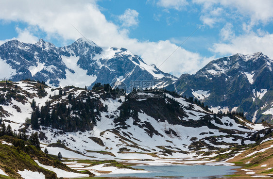 夏季阿尔卑斯山向霍赫坦贝戈帕斯和雪融化草地奥利沃斯拉尔贝格的小卡莱西湖看望夏季阿尔卑斯山图片