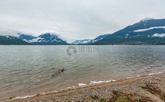 Como湖意大利夏季风云山顶上有雪图片