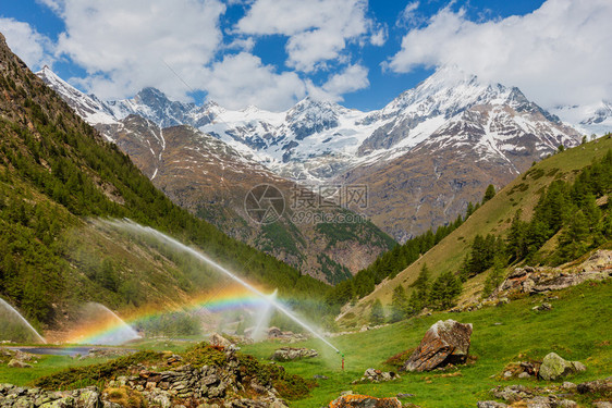 夏季阿尔卑斯山瑞士Zermatt附近灌溉水龙头中的彩虹图片