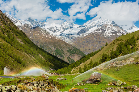 夏季阿尔卑斯山瑞士Zermatt附近灌溉用水插口中的彩虹图片