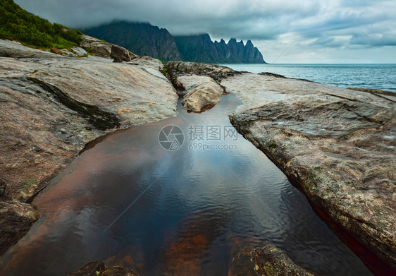 挪威Senja市Ersfjord的沙滩上有潮汐浴夏季极地日夜海岸远处的龙牙岩图片