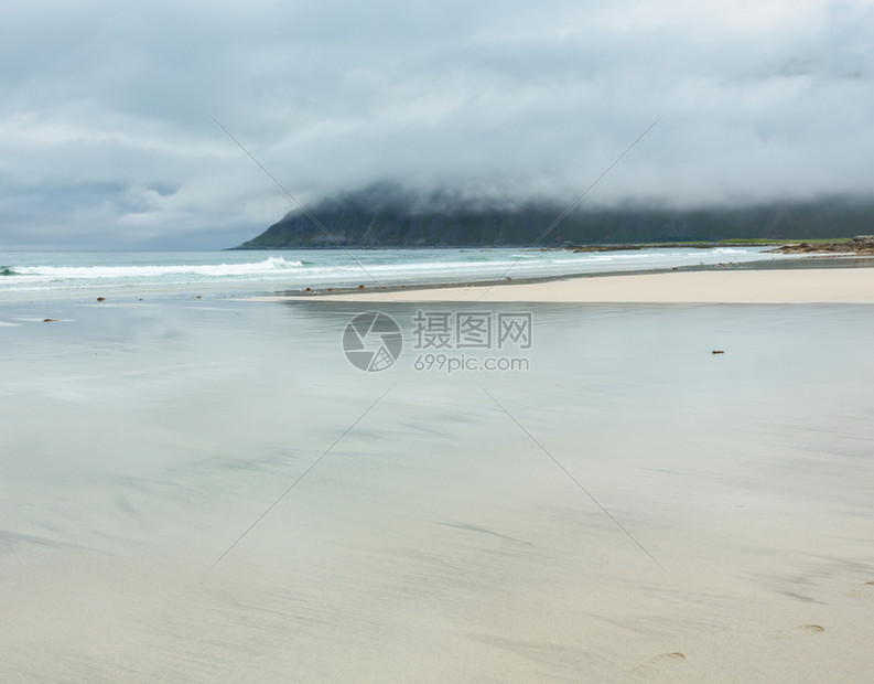 夏季雾和多云的海滩风景波浪水中的天空反射覆盖白沙RambergLofoten挪威图片