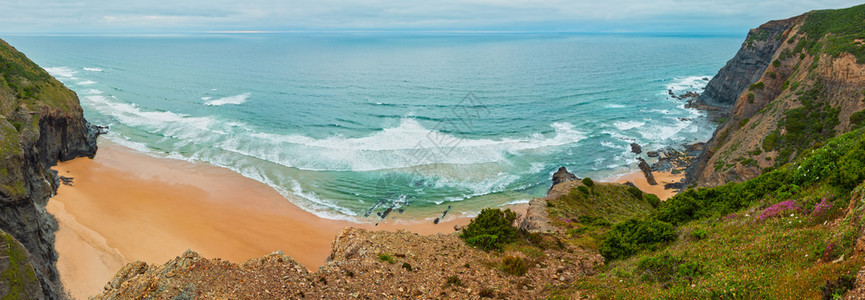 在夏季大西洋岩石海岸维琴蒂纳州阿尔加维葡萄牙和海洋浪中桑迪海滩上布满了石脊覆盖夏季大西洋岩石海岸的天气景象图片