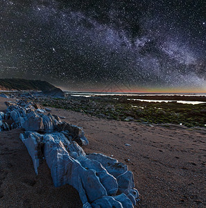 夜间海洋岸从滩看边有大石头天空星状银河法国圣让德卢斯比凯湾图片