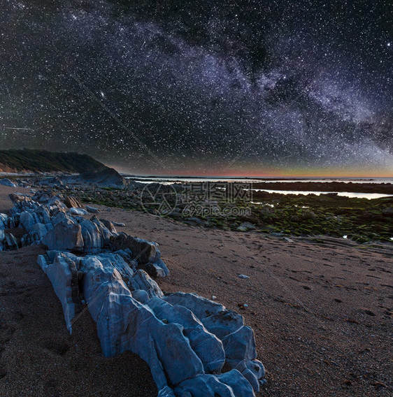 夜间海洋岸从滩看边有大石头天空星状银河法国圣让德卢斯比凯湾图片