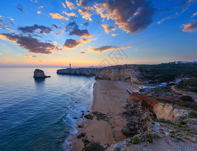 海边的日落景色与本塔多祭坛灯塔普拉亚达阿富拉达海滩西景费拉古多拉戈亚阿尔加维葡萄牙图片