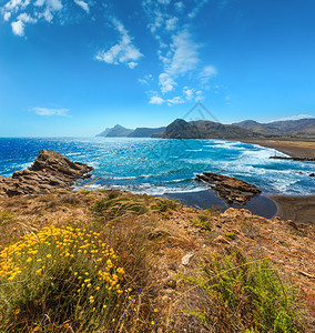 前面是夏季沙滩和黄花地中海岸景观波曼湾科斯塔布兰卡西班牙图片