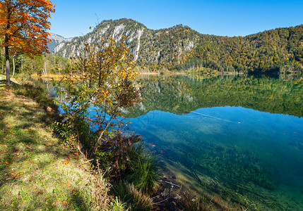 阳光明媚多彩的秋天风景和平的山湖有清晰透明的水和反射图片