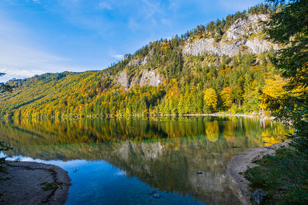 阳光明媚多彩的秋天风景和平的山湖有清晰透明的水和反射兰巴西恩湖上奥地利人们无法辨认图片