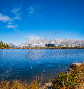 和平秋天的阿尔卑斯山湖有清晰透明的水和反射物以及滑雪升降站图片