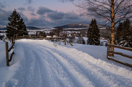 偏远山村道路雪流和木栅栏图片