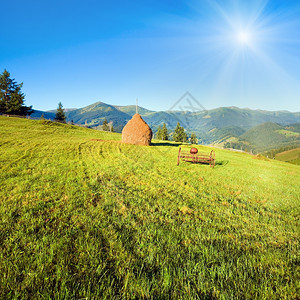 夏季山村用田地干草堆和旧磨机在山村外挖土图片