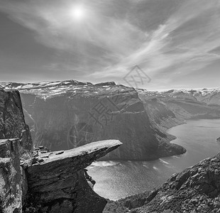 灰度夏季太阳光照着Trolltunga著名的Troll北欧舌头目地和挪威罗达尔奥的Ringedalsvatnet湖图片