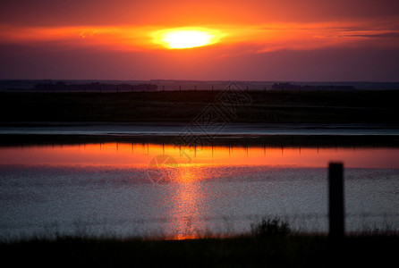 加拿大萨斯喀彻温省草原日出反射在湖面上图片