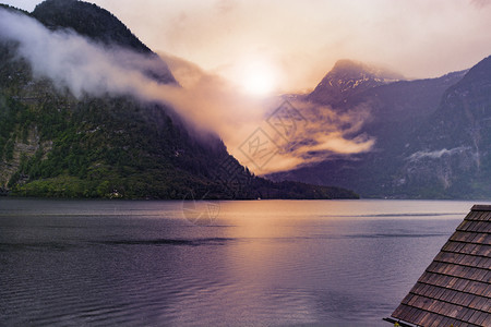 奥地利Hallstattersee的雨和云在日出时奥地利清晨的雾散落在奥地利的风景上有湖泊森林田地牧场草原和瓷砖屋顶图片