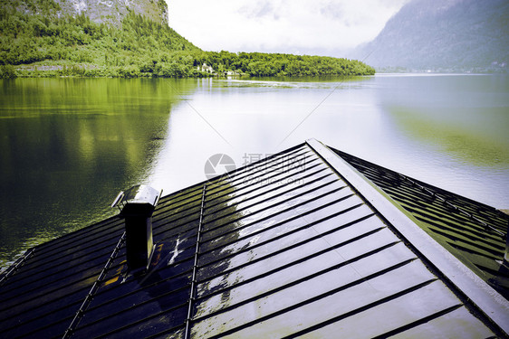 奥地利Hallstattersee的雨和云清晨的雾散落在奥地利的风景上有湖泊森林田地牧场草和湿屋顶Retro风格图片