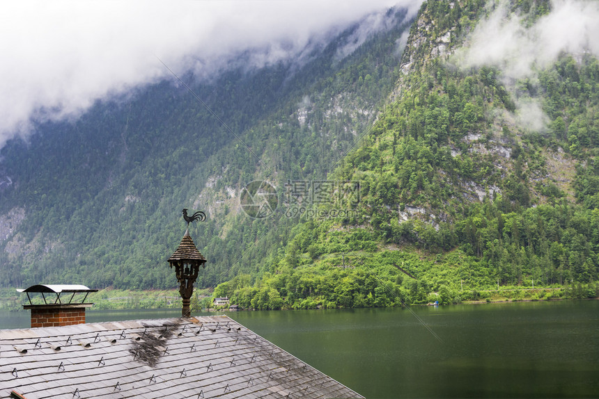 奥地利Hallstattersee的雨和云早上奥地利的风云覆盖着湖泊森林田地牧场草原和湿屋顶图片