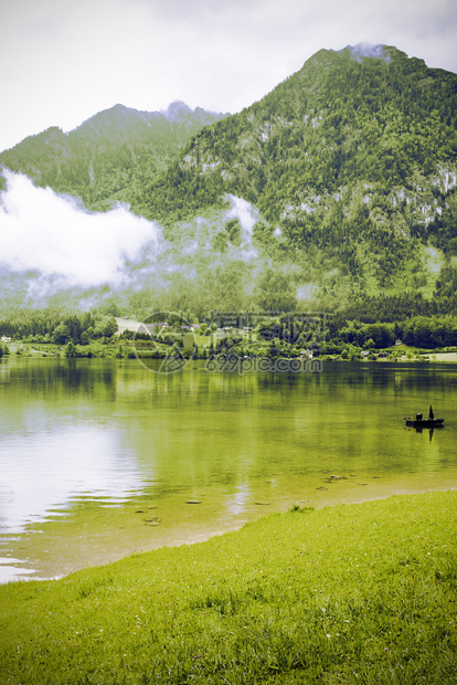 奥地利Hallstattersee的雨和云清晨的雾笼罩在奥地利的风景上有湖森林田地牧场草原和村庄图片