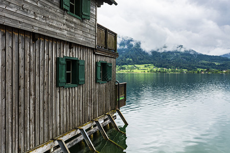 奥地利沃尔夫冈赛的雨和云早上在奥地利风景喷雾湖船库森林牧场草地和村庄图片