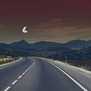 西班牙在月光下收割后在西班牙田地之间行走的干草道路图片