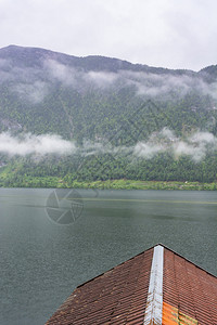奥地利Hallstattersee的雨和云层早上在奥地利的貌上喷雾湖森林农田牧场草原和瓷砖屋顶图片