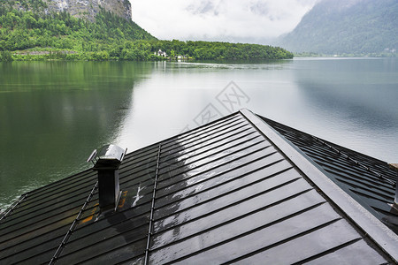 奥地利Hallstattersee的雨和云早上奥地利的风云覆盖着湖泊森林田地牧场草原和湿屋顶图片