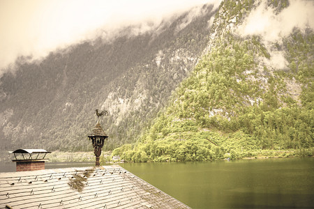 奥地利Hallstattersee的雨和云清晨的雾散落在奥地利的风景上有湖泊森林田地牧场草和湿屋顶Retro风格图片