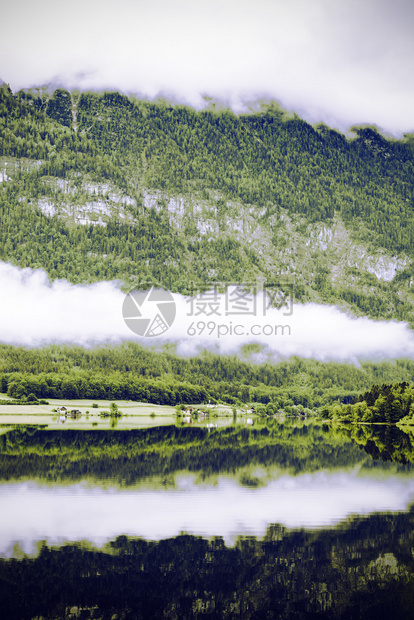 奥地利Hallstattersee的雨和云清晨的雾笼罩在奥地利的风景上有湖森林田地牧场草原和村庄图片