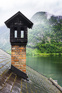 奥地利Hallstattersee的雨和云早上奥地利的风云覆盖着湖泊森林田地牧场草原和湿屋顶图片