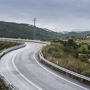 风电塔筒西班牙有隔离屏障的风路沥青西班牙农村的风景田间有电塔高速公路有压线背景