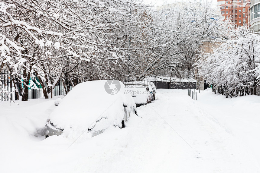 在莫斯科市住宅区横渡冬季日在莫斯科市住宅区沿公路停车的上放雪覆盖汽车图片