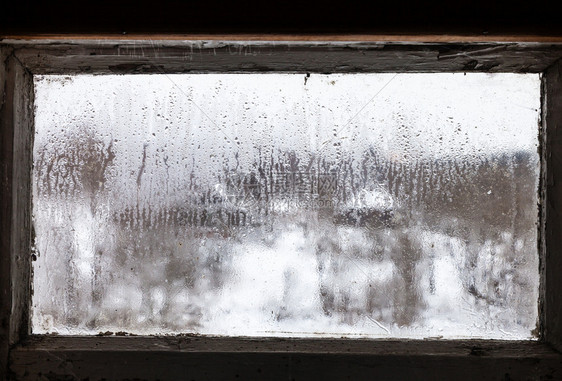 在寒冷的冬季农村住宅被错误冷冻的窗户上放水对俄罗斯村庄进行模糊的观察重点是玻璃上的冰面图片