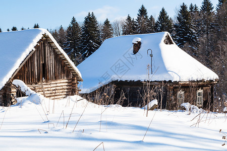 俄罗斯摩伦克地区小村庄中阳光明媚的冬季日落在森林边缘的荒废农村老房子被雪覆盖在俄罗斯摩伦克地区小村庄中图片