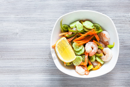印度菜新鲜蔬菜和虾的沙拉白碗灰色木桌有免费复制空间图片