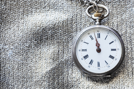 在银纺织背景的古董口袋手表上2分钟到1时分图片