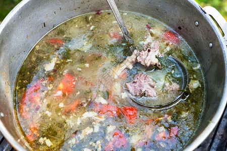 户外锅炉烹饪的中央肉类沙帕和大片菜的酱图片
