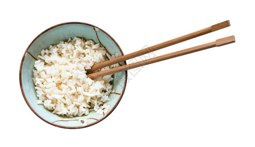 碗中筷子的顶部视图白底盘中孤立的煮饭大米图片