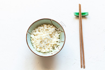 在白混凝土板上用煮饭米和木棍做休息的杯子顶端视图图片