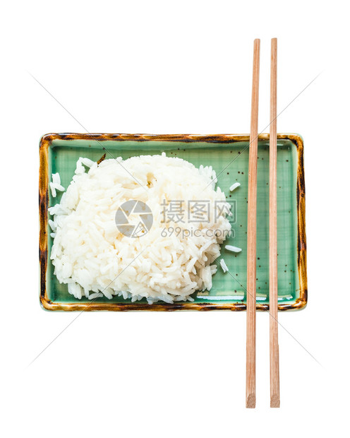 白底隔离的绿色板块上煮饭米和筷子顶部视图图片