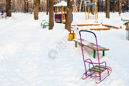 冬日暮色中城市公园里的操场被白雪覆盖在冬天的暮色中图片