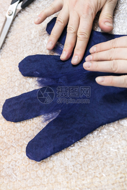 用湿感觉工艺蓝梅里诺羊毛用手套制工匠在湿手套指上放纤维图片