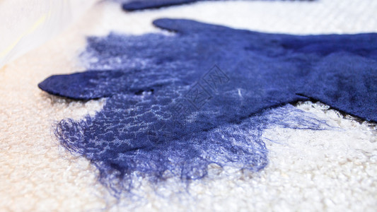 用湿感应工艺蓝色梅里诺羊毛用手套制成湿感应手套另外的纤维被割断紧闭图片
