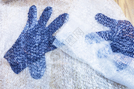 用湿感觉过程蓝色梅里诺羊毛用手套做滚动和按紧后垫子上感觉手套图片