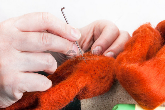 使用针感知工艺来修补羊毛手套的硕士班手工艺人用针感应器修补衣服图片