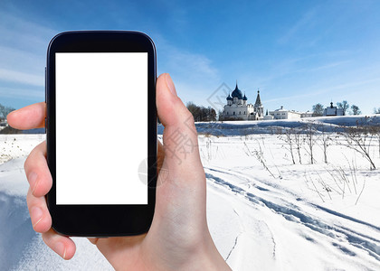 旅行概念俄罗斯冬季苏达尔镇与Chathedral和宫殿一起用智能手机拍摄俄罗斯冷冻河流和苏兹达尔克里姆林宫的旅游照片带有剪切屏空图片