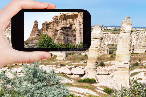 旅游概念春季在土耳其卡帕多西亚戈雷梅公园卡帕多西亚山上用智能手机拍摄的古老仙子烟囱岩的景观旅游照片图片