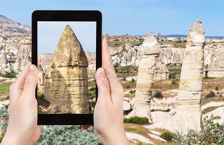 旅游概念春季在土耳其卡帕多西亚戈雷梅公园卡帕多西亚山上用智能手机拍摄的古老仙子烟囱岩的景观旅游照片图片