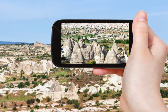 旅行概念春季在土耳其卡帕多西亚戈雷梅公园用智能手机拍摄山谷带仙子烟囱岩的旅游照片图片